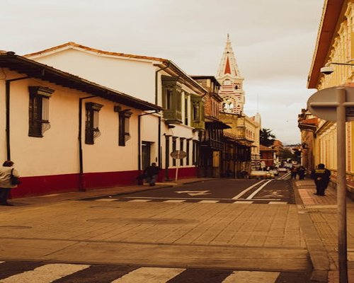 Personas caminando tranquilamente por una calle de Bogotá durante la mañana