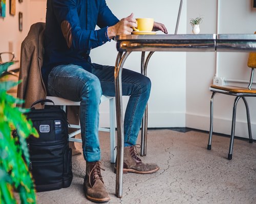 Persona sirviéndose un café en la oficina, aprovechando para estar de pie